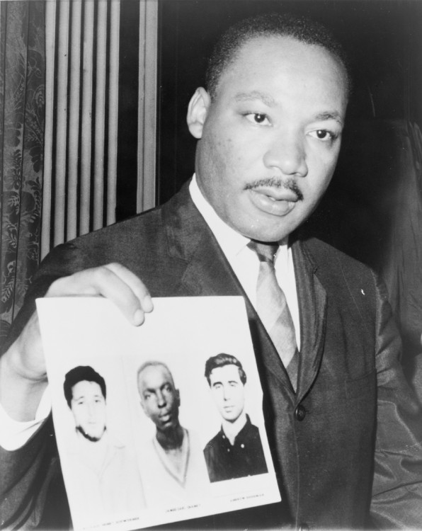 Dr. Martin Luther King Jr., a founder of the Southern Christian Leadership Conference (SCLC) holds a picture of the three CORE workers killed during Freedom Summer in Mississippi, 1964. The three were registering black voters.
