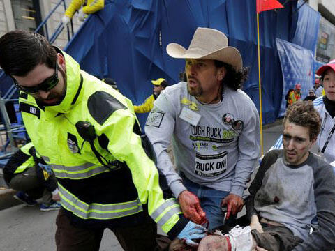 Carlos Arredondo was waiting at the Boston Marathon finish line for runners who were racing on behalf of fallen soldiers -- one of those fallen soldiers being Arredondo's son -- and handing out American flags when the blast went off across the street. He ran to help injured spectators, including Jeff Bauman, whose legs were blown off. Arredondo can be seen, wearing a cowboy hat, in an iconic photo, apparently holding the Bauman's severed artery, NBC News reports.