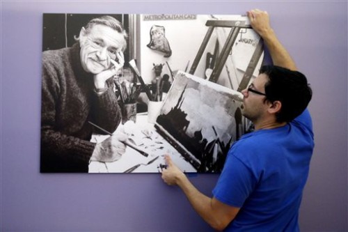 In this Tuesday, July 16, 2013 photo, exhibition technician Ryan Will hangs an image for The Snowy Day and The Art Of Ezra Jack Keats exhibition at the National Museum of American Jewish History, in Philadelphia. The exhibition opened July 19.  (AP Photo/Matt Rourke)