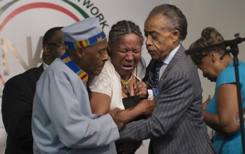 Esaw Garner, wife of Eric Garner, breaks down in the arms of the Revs. Herbert Daughtry (left) and Al Sharpton (right) during a rally on Sunday