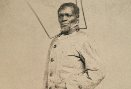 Slave Punishment: Wilson Chinn, a freed slave from Louisiana, poses with equipment used to punish slaves. Such images fueled Northern resolve against slaveholders during the American Civil War (photographed in 1863). (Photo Credit: CORBIS)
