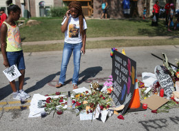 FERGUSON, MO - AUGUST 19: Lakiah Payne (L) and Michael Brown's sister, Deja Brown, visit a memorial for him that is setup on the spot where he fell after he was shot by police on August 19, 2014 in Ferguson, Missouri. Protesters have been vocal asking for justice in the shooting death of Michael Brown by a Ferguson police officer on August 9th. (Photo by Joe Raedle/Getty Images)