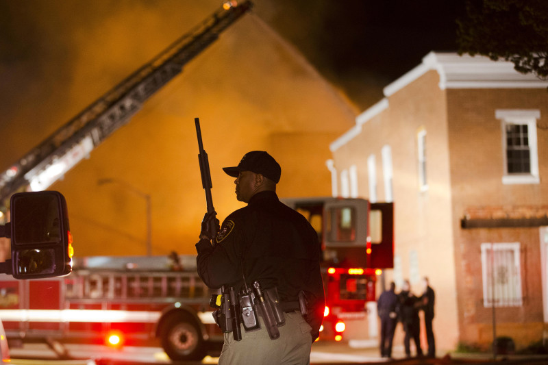 An officer stands near a blaze on April 27, 2015.