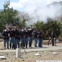 An honor guard fires a ceremonial salute.