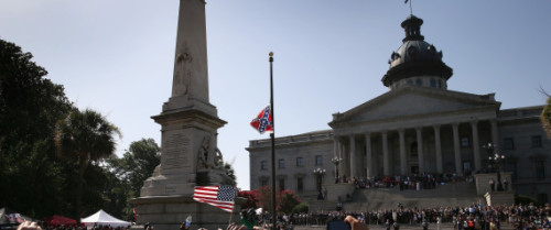 COLUMBIA, SC - JULY 10:  A crowd cheers as a South Carolina state police honor guard lowers the Confederate flag from the Statehouse grounds on July 10, 2015 in Columbia, South Carolina. Republican Governor Nikki Haley presided over the event after signing the historic legislation the day before. (Photo by John Moore/Getty Images)