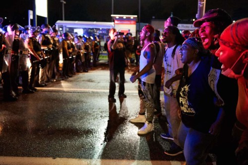 Protesters face police officers on West Florissant Avenue in Ferguson, Missouri on August 9, 2015. 