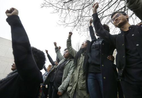 Students at Boston College raise their arms during a solidarity demonstration on the school's campus. (AP Photo/Steven Senne)
