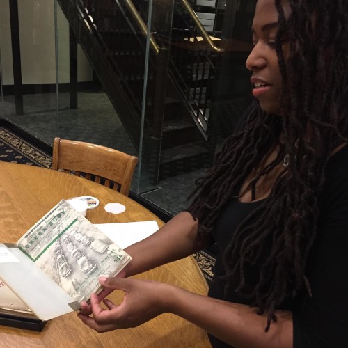 Cunningham sits on the board of the Dr. James Cameron Legacy Foundation, which runs America's Black Holocaust Museum. Here she displays the Negro Motorist's Guide (also known as the Green Book) of 1936. Photo: Jim Higgins