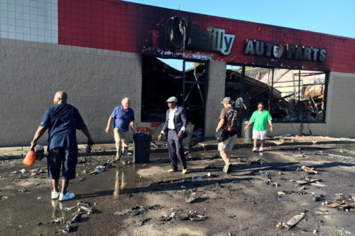 The morning after angry youth burned several businesses following the police killing of a young black man, neighbor residents came out to clean up.