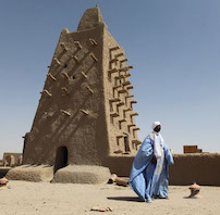 A man stands in front of the Djingareyber mosque on February 4, 2016 in Timbuktu, central Mali. 
Mali's fabled city of Timbuktu on February 4 celebrated the recovery of its historic mausoleums, destroyed during an Islamist takeover of northern Mali in 2012 and rebuilt thanks to UN cultural agency UNESCO.
TO GO WITH AFP STORY BY SEBASTIEN RIEUSSEC / AFP / SÉBASTIEN RIEUSSEC