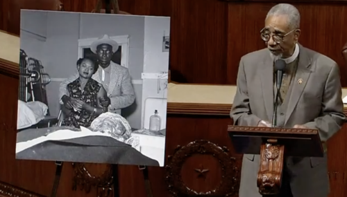 Rep. Bobby Rush stands on the U.S. House floor next to a photograph of Mamie Till and her future husband, Gene Mobley, as she views her son Emmett's body. R (Image is a still from C-SPAN video.)