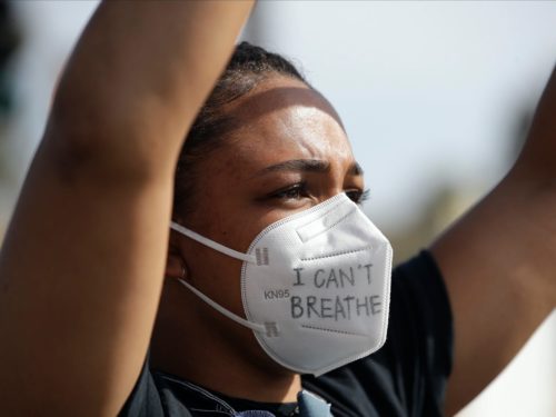 BLM protester with an "I can't breathe" mask on and her arms up