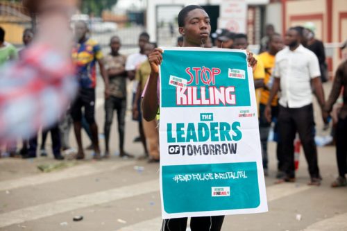97475a01-cc39-41e0-a5c2-359ce6c9fa0d-EPA_10967265e A boy holds a banner during a protest against the Nigeria rogue police, otherwise know as Special Anti-Robbery Squad (SARS) in Lagos, Nigeria on Oct. 20, 2020