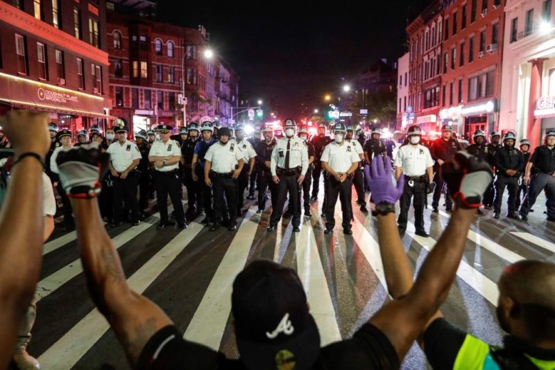 protesters take a knee in front of NYPD police line