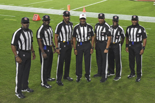 NFL officials, from left, umpire Barry Anderson, field judge Anthony Jeffries, down judge Julian Mapp, referee Jerome Boger, back judge Greg Steed, side judge Dale Shaw (104), line judge Carl Johnson (101) pose for a photo before an NFL football game between the Tampa Bay Buccaneers and the Los Angeles Rams Monday, Nov. 23, 2020, in Tampa, Fla. The game is the first in NFL history to feature an all African-American officiating crew. (AP Photo/Jason Behnken)