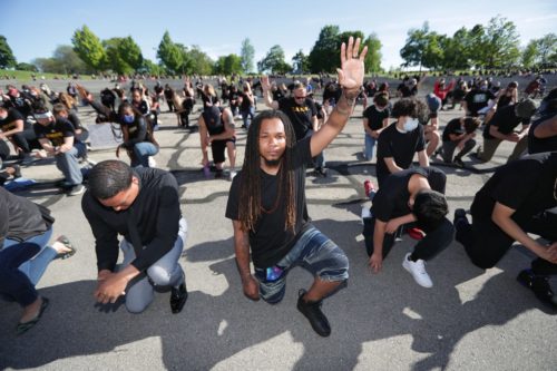 Terry Thompson and protesters take a kneww