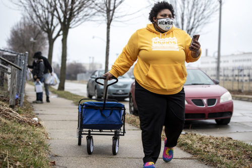 Vaccine-Access-02 Melody McCurtis, a deputy director at Metcalfe Park Community Bridges, pulls a container filled with COVID-19 vaccine information for Milwaukee residents on March 27, 2021. Her group worked with the city health department and Milwaukee nonprofits to launch vaccination clinics open to residents 16 and older who live in Milwaukee’s Metcalfe Park and Amani neighborhoods. “We're seeing the effects of what access, real outreach and commitment does to a community that has been oppressed and almost left on the back burner for almost a year now,” McCurtis says. (Angela Major/WPR)