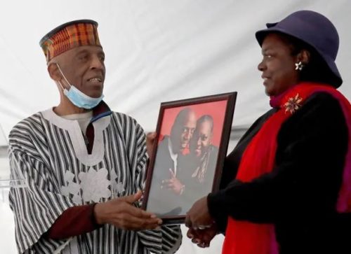 Capture Reuben Harpole and his daughter with a photo of Reuben and his late wife Mildred, both celebrated community activists.