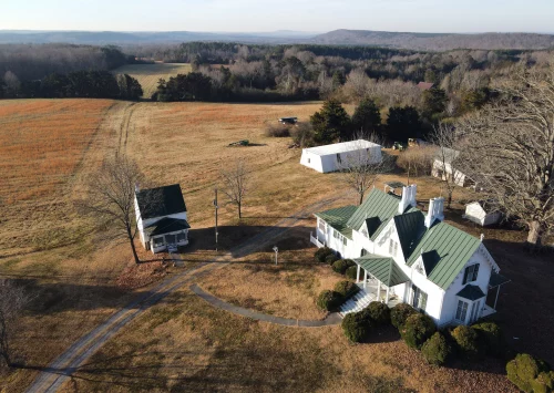 plantation Sharswood in Gretna, Va., was built in the middle of the 19th century and at one point was the hub of a sprawling plantation. The Pittsylvania County property now consists of 10½ acres. Out of the frame behind the large tree at right is a cabin that may have been used by enslaved people as a kitchen and laundry for the main house as well as a residence. (Heather Rousseau for The Washington Post)