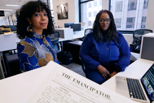 Amber Payne, left, and Deborah Douglas co-editors-in-chief of the new online publication of "The Emancipator" pose at their office inside the Boston Globe, Wednesday, Feb. 2, 2022, in Boston. Boston University's Center for Antiracist Research and The Boston Globe's Opinion team are collaborating to resurrect and reimagine The Emancipator, the first abolitionist newspaper in the United States, which was founded more than 200 years ago. (Charles Krupa via Associated Press)