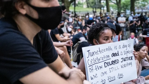 A protestor holds a sign about the significance of Juneteenth (Twitter/@TheHill)