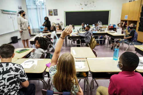 A student raises her hand in a classroom at Tussahaw Elementary School in McDonough, Ga., on Aug. 4. (Brynn Anderson / AP)