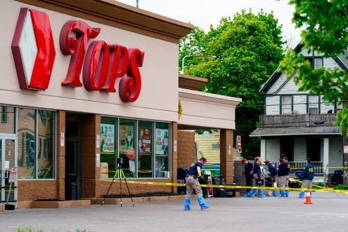 Investigators work the scene after a mass shooting at a supermarket in Buffalo last month. (Matt Rourke/AP)