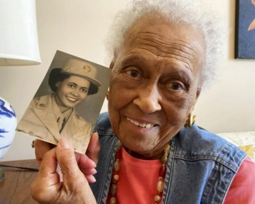 Davis poses with a picture of her younger self in her WWII uniform (AP Photo/Jay Reeves)