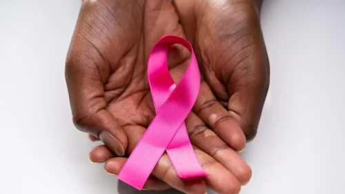 Black hands hold a breast cancer awareness ribbon (Adobe Stock)