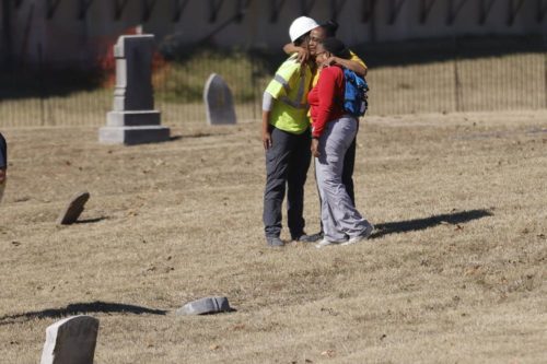 1921 Graves Public Oversight Committee member Brenda Alford, center, hugs state archaeologist Kary Stackelbeck, left, and forensic anthropologist Phoebe Stubblefield at Oaklawn Cemetery searching on Wednesday. (Mike Simons/Tulsa World via AP)