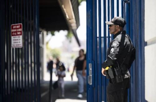 A Fullerton police sergeant stands near the entrance to Richman Elementary School in Fullerton, Calif., on May 25. (Paul Bersebach / Orange County Register via Getty Images)