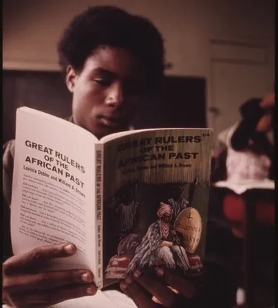 A Black man reading "Great Rulers of the African Past"