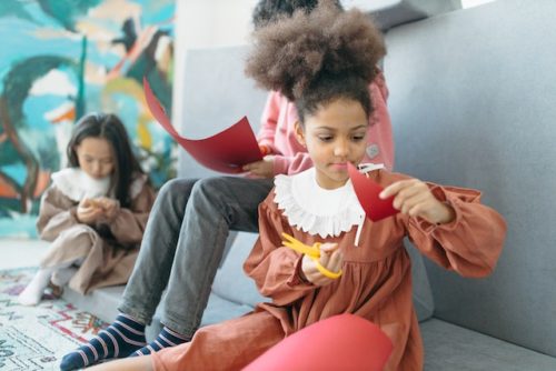 Black girl with curly hair cuts paper