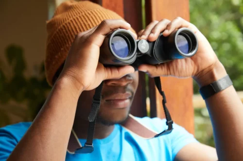 Black man using binoculars
