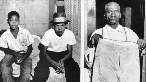 Simeon, 12, and Maurice Wright, 16, cousins of Emmett Till, sit in their home after being questioned after his disappearance. Moses Wright, 64, great uncle of the murdered boy, holds some of Emmett's clothing to show that he was a "large boy for his age." (Bettmann Archive/Getty Images)