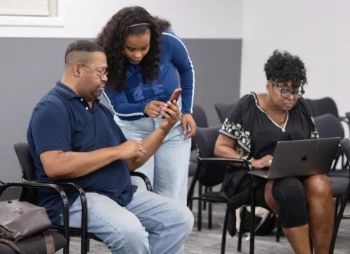 University of Illinois graduate student McKenzie Macon, center, helps Evanston resident Gerald Johnson with a DNA kit as part of the TAKiR project on July 3, 2025, at Evanston City Hall. (John Konstantaras/for the Pioneer Press)