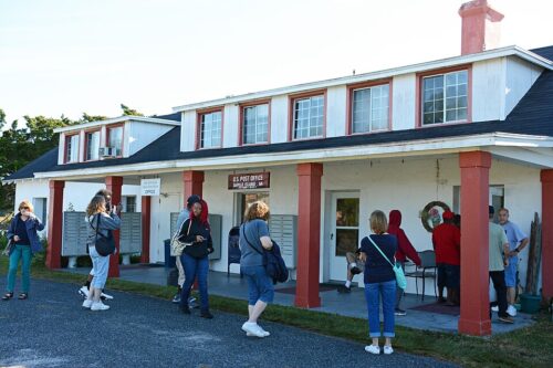 People in front of a building housing the Hogg Hammock store and Post Office in Hogg Hammock