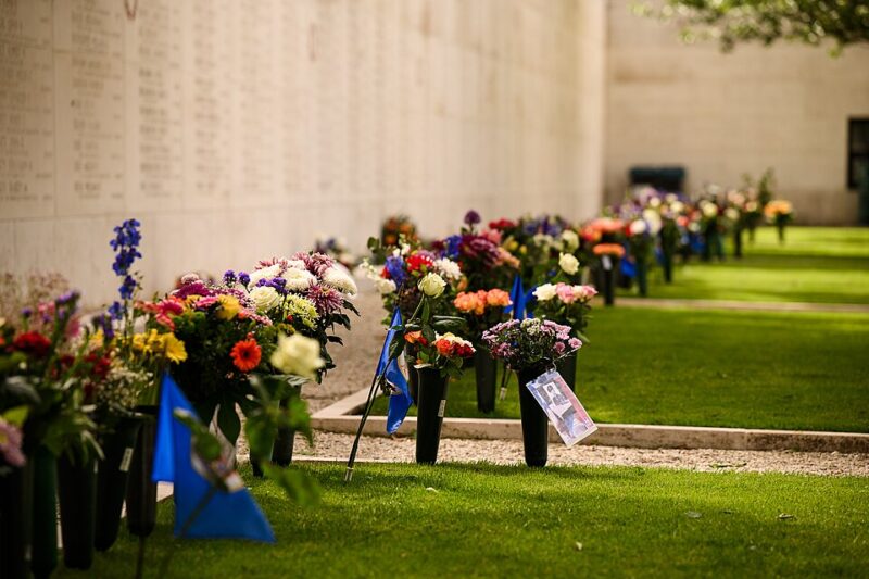 Flowers on the ground near a memorial in the Netherlands American Cemetery