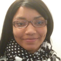 Jada Elizabeth Johnson, a Black woman in glasses, looking at camera