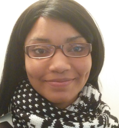 Jada Elizabeth Johnson, a Black woman in glasses, looking at camera