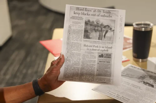 Lennie Mosley, one of the original Halyard Park residents, holds up a newspaper clipping about the Halyard Park neighborhood.